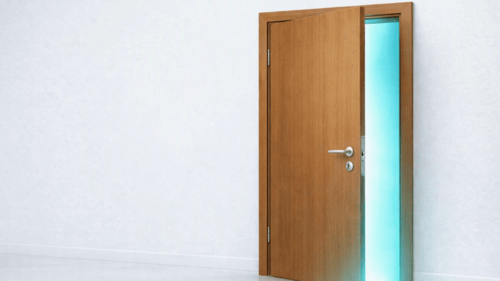Puerta de madera entreabierta con luz turquesa que simboliza el proceso de offboarding y la transición profesional.